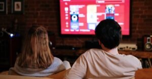 IPTV free trial. A couple enjoys streaming shows on a large TV in a cozy, brick-walled living room.